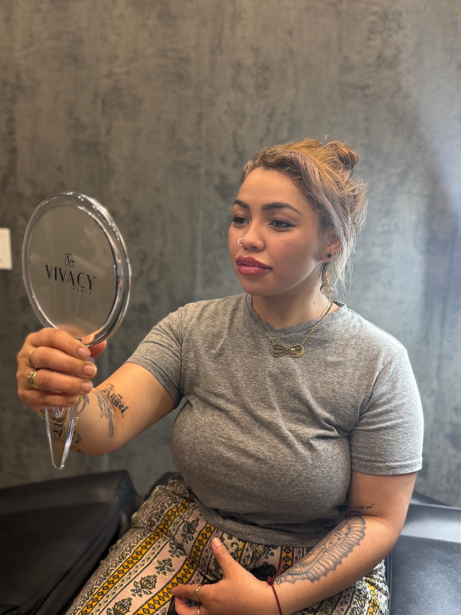 Client viewing lip filler treatment in a hand mirror